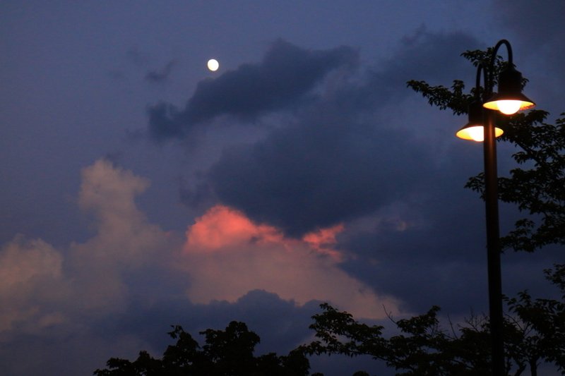 月が昇りブルーに変わっていく空。東の空に高くそびえる入道雲は、まだ赤く染まってます。　2018年8月5日撮影