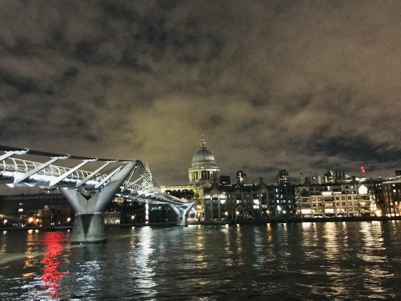 Millennium Bridge over Thames with St. Paul's Cathedral in London。