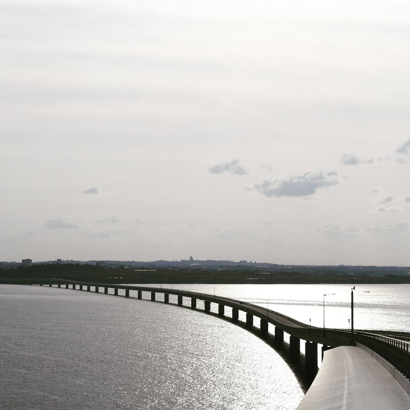 欄干からの橋像は弧を描き，そのシルエットが海面にアーク状に投影．河の橋で見られにくいスケープです．