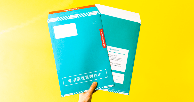 年末調整書類があつまる封筒を持った手の写真
