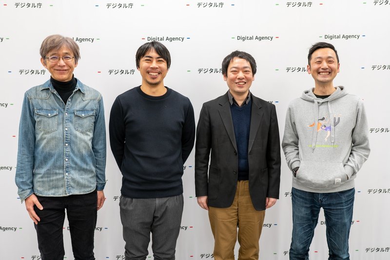 男性4人が立って横に並んでいる写真。左から及川さん、水島、吉田、関さんの順に並んでいる