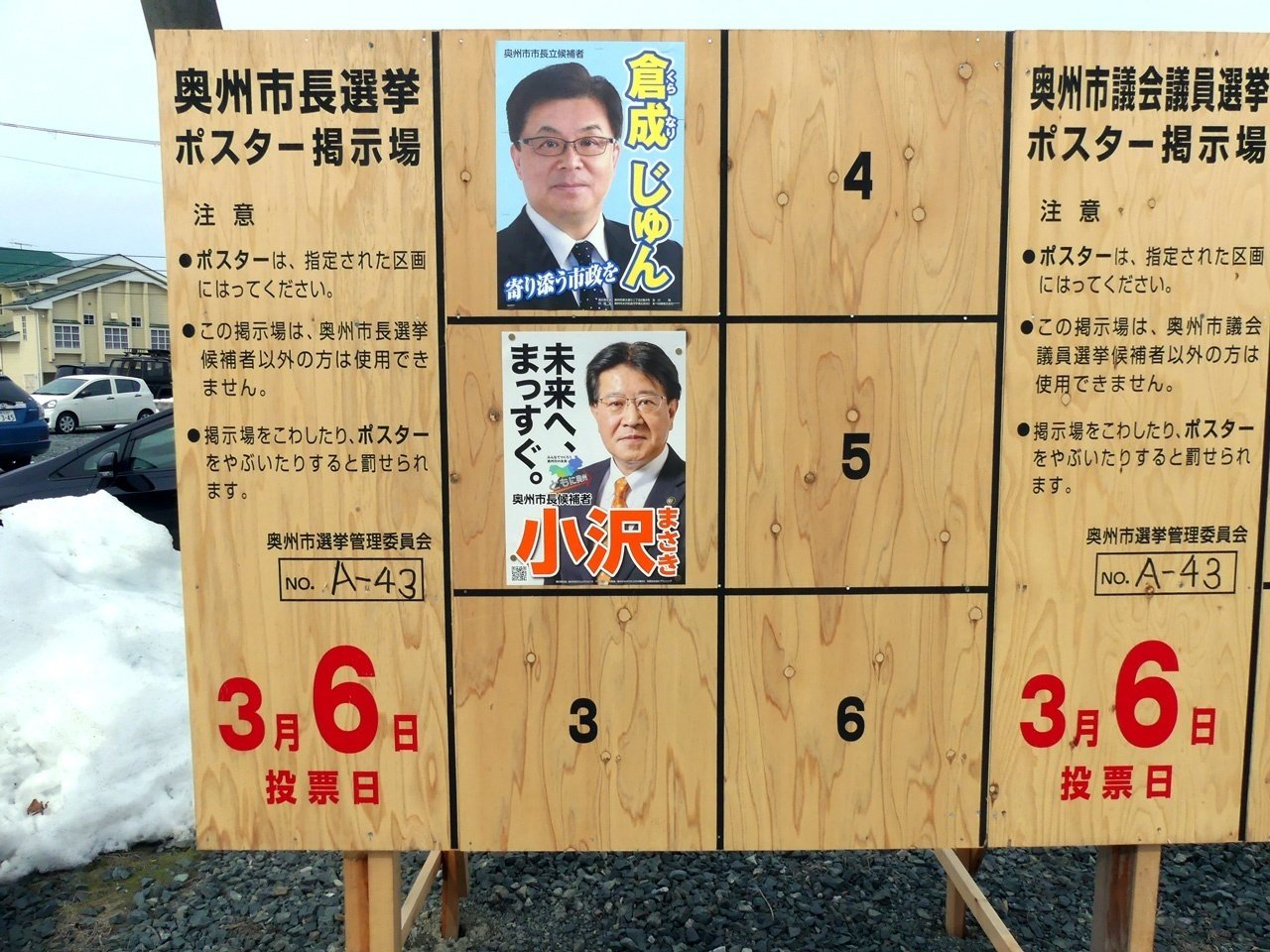 奥州市長選の選挙ボード。倉成淳さんと小沢昌記さんのポスターが貼られている。