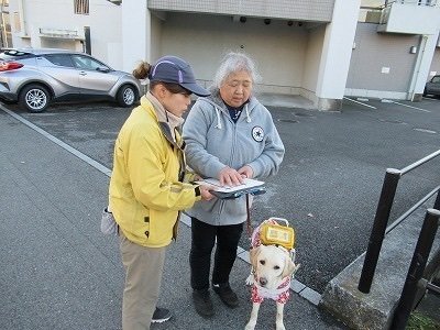 自宅付近の道路をユーザー、盲導犬と訓練士が確認している写真