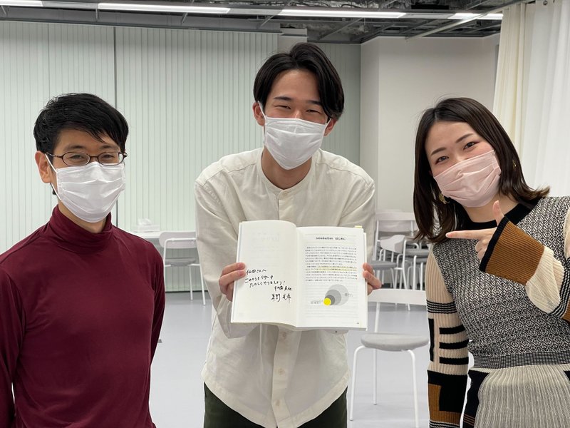 草野さんと松薗さん、2人のサイン入り著書を手にもった筆者がこちらを見て笑っている写真