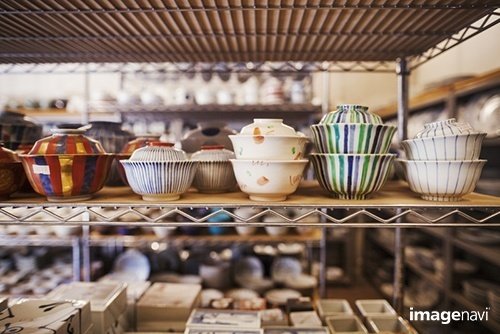  Close up of selection of ceramic bowls with lids on a shelf in a Japanese porcelain workshop.｜Mint Images