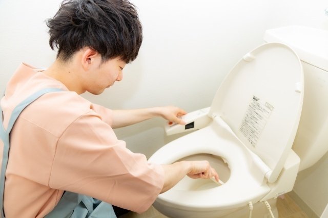 トイレ掃除をする男性