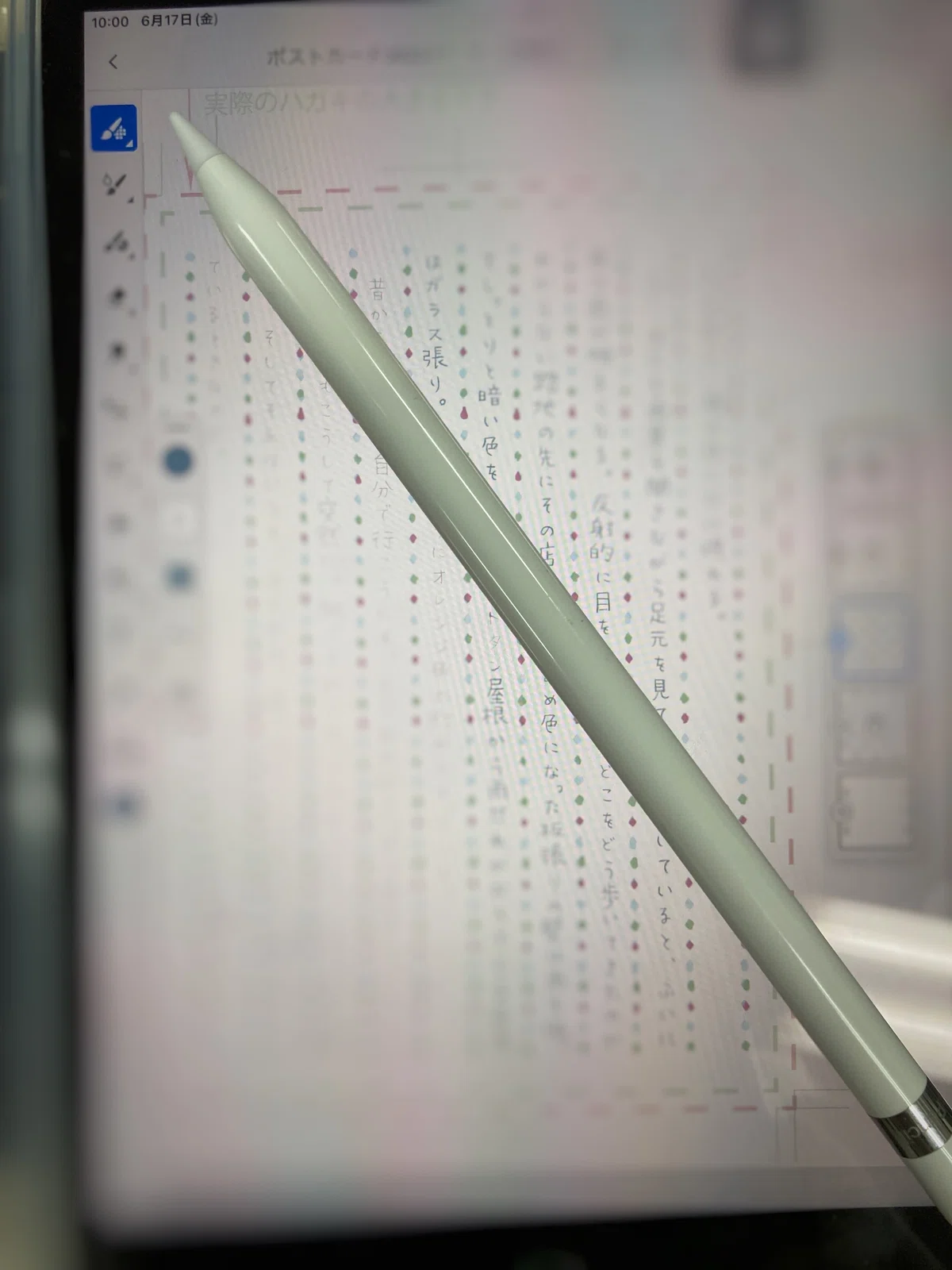 iPadの上にAppleペンシルが置かれた写真。画面には活字が縦書きされている様子。