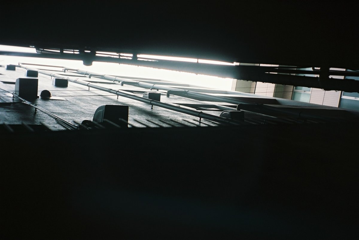 建物の隙間から見える空のフィルム写真。