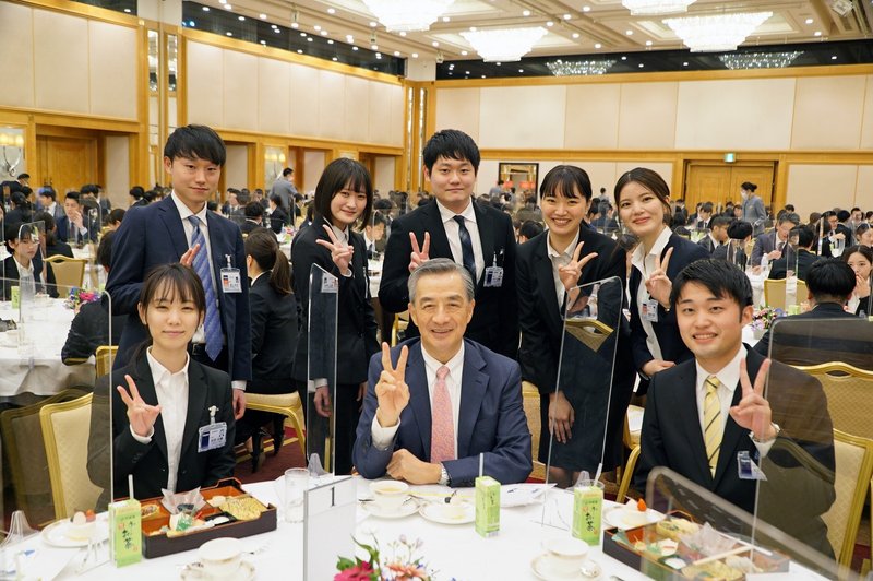 入社式で新入社員と懇談する野島廣司さん(中央)=2022年4月1日
