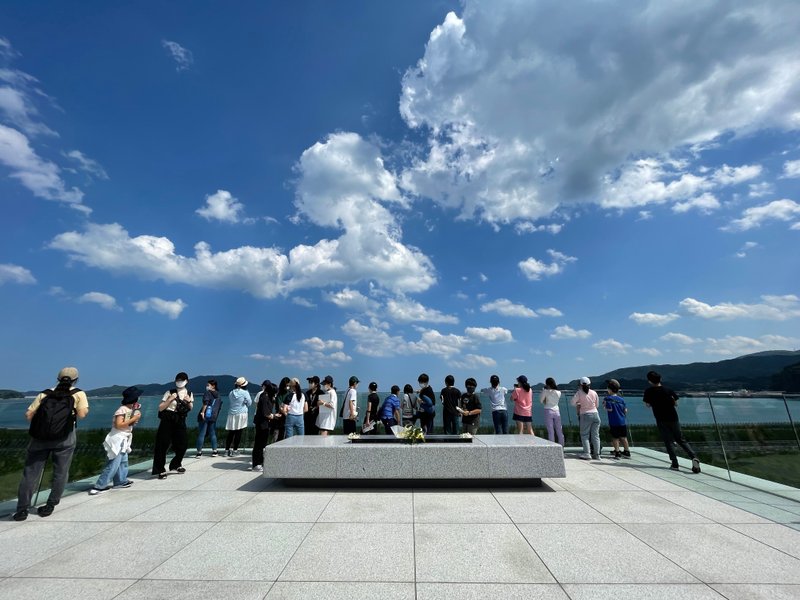 震災伝承館の近くでひらけた海を見る子どもたちの画像