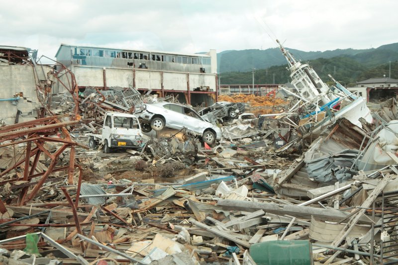 東日本大震災当時の瓦礫や車、船が重なっている画像