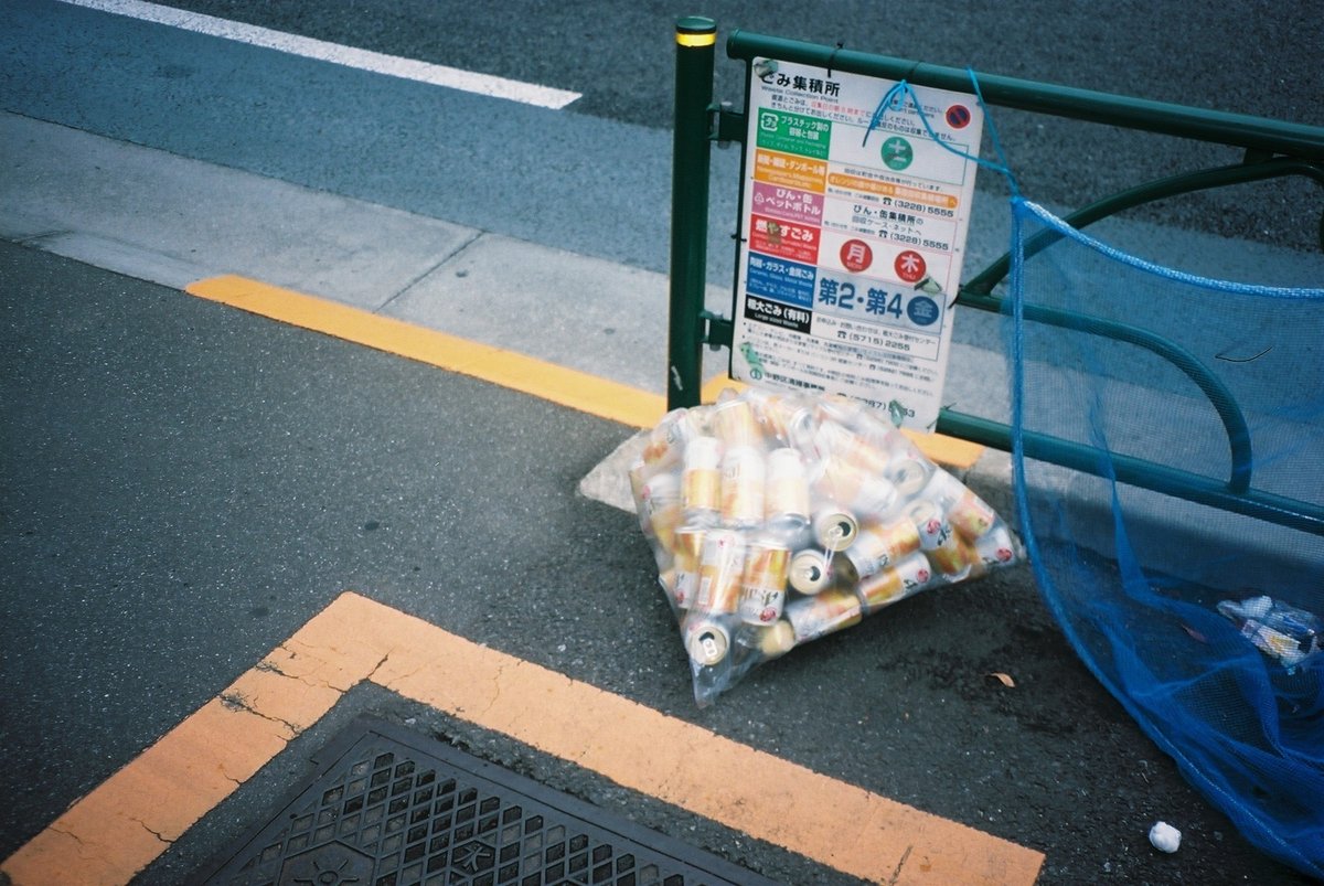 ゴミステーションに出された同じ銘柄のビールのゴミのフィルム写真。