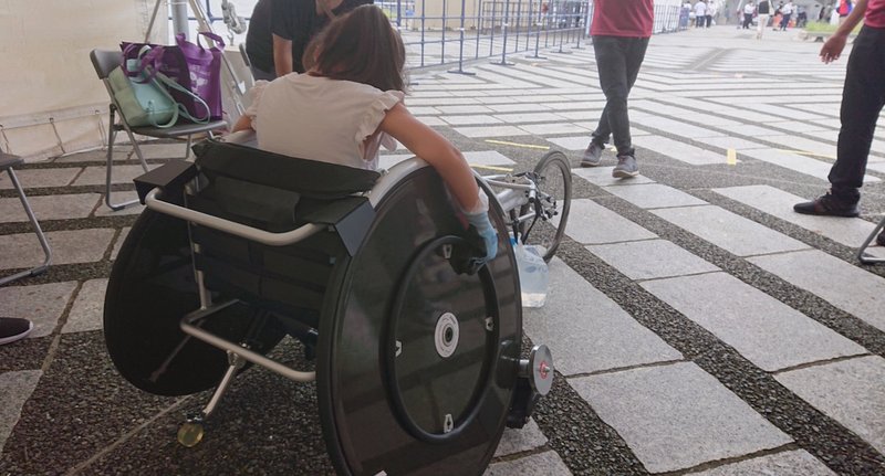 パラ陸上のレース用車椅子を体験する女児児童