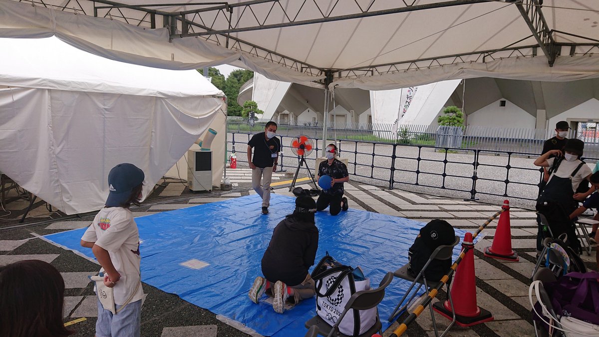 People trying out goalball on a blue tarp