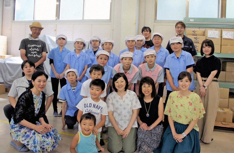 清水直子さん(前列左端)とファイン本社や三重・伊賀工場の社員、家族たち=2018年本人提供