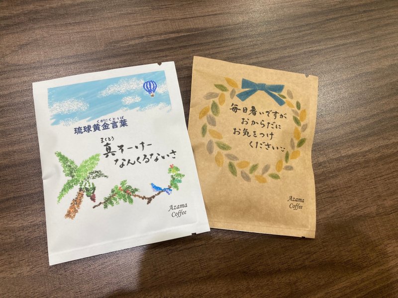 安座間珈琲さんのメッセージが書かれたドリップパックコーヒー２袋（琉球くがにくとぅば　まくとぅそーけーなんくるないさ、毎日暑いですがおからだにお気をつけください😌）の写真