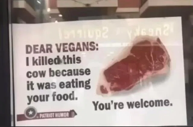 店のガラスに貼られた紙に生肉の写真が印刷してあり、その横に次の英文が書いてある「Dear Vegans: I killed this cow because it was eating your food. You're welcome.」