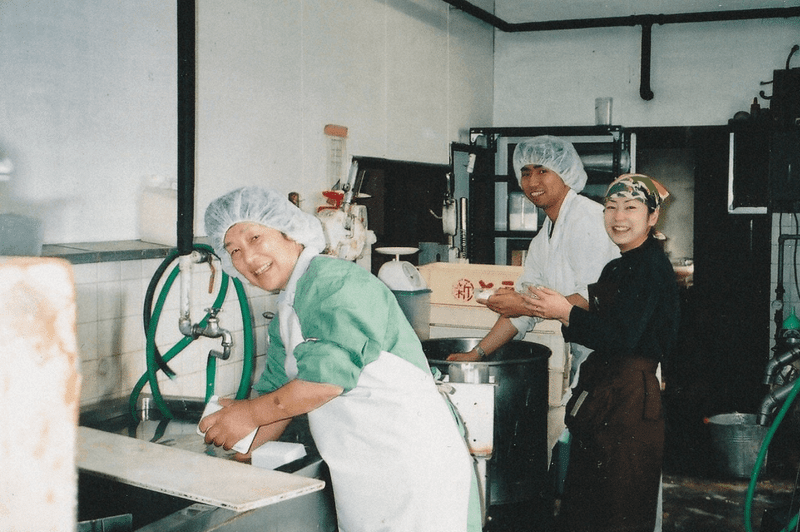 家族でお豆腐を作る小野篤人さん(中央奥)=2004年、本人提供