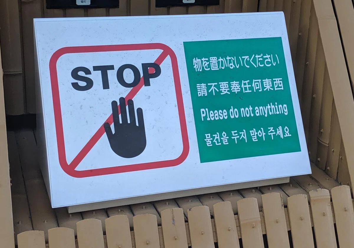 物を置かないでください、の看板の横に英語で「Please do not anything」