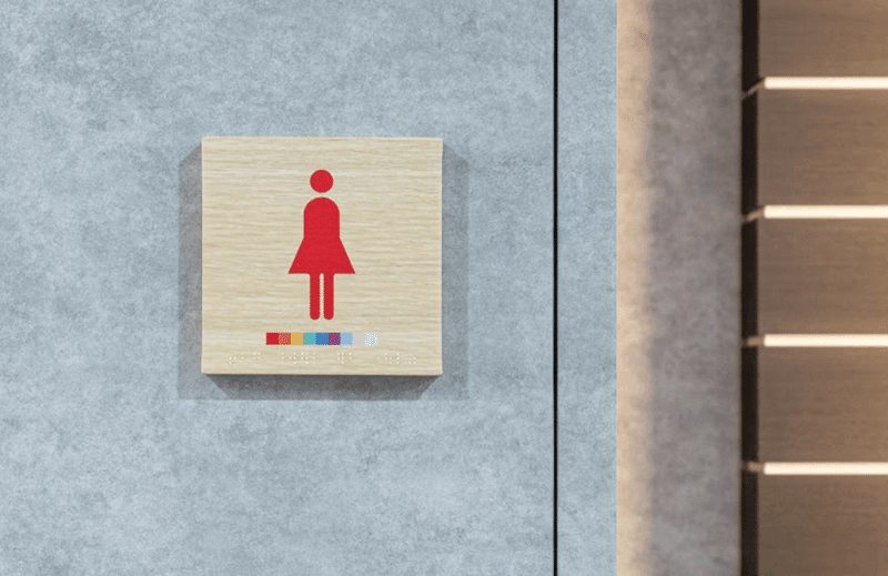 性自認トイレのサイン。女性を示すマークの下に虹色が掲載された様子。