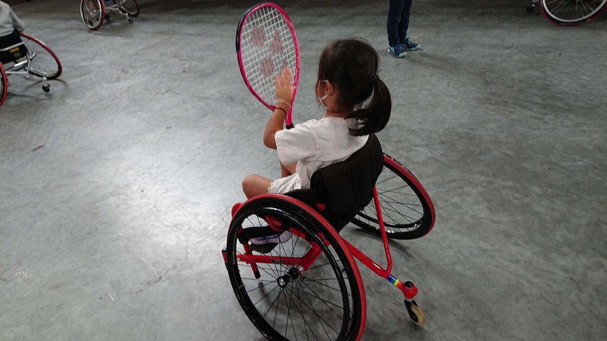 A girl trying out wheelchair tennis