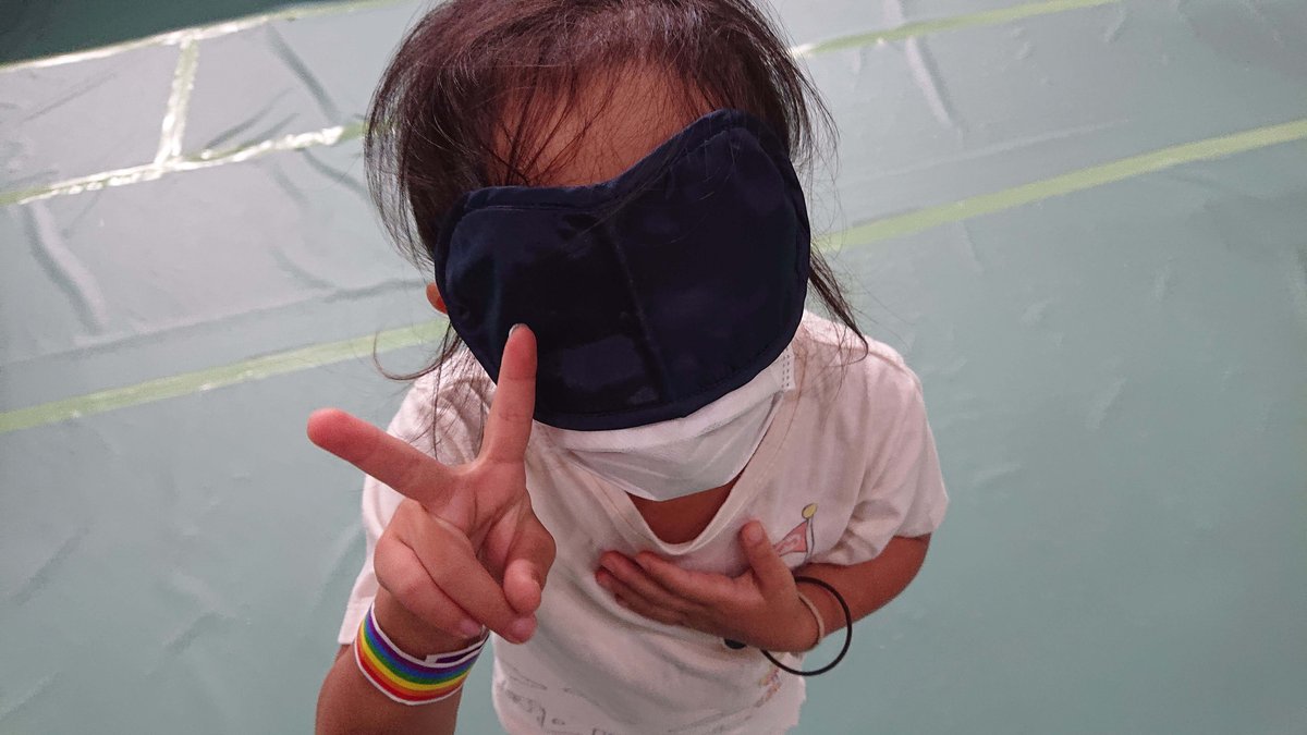 Girl wearing eye mask making peace sign