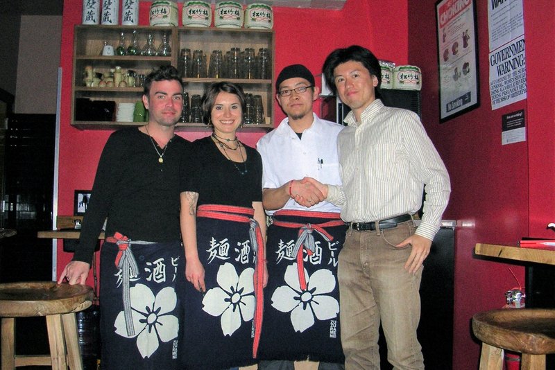エニシングの西村和弘さん（右）は前掛けのサンプルを作製してニューヨークの料理店を訪ね歩いた＝2009年 本人提供