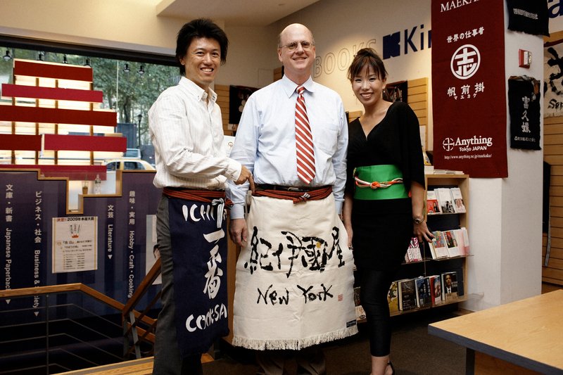 紀伊国屋書店ニューヨーク店で前掛けの展示会を開いた西村和弘さん（左）＝2009年 本人提供
