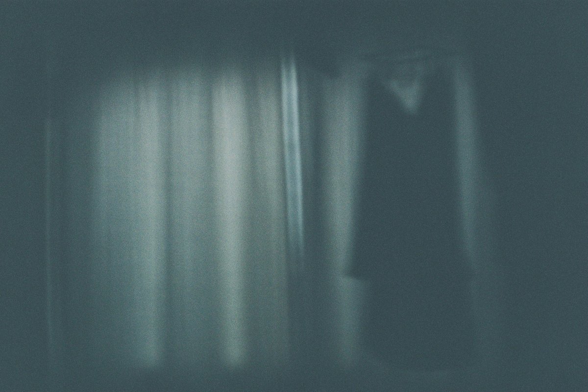 明け方の暗い部屋の窓辺のフィルム写真。