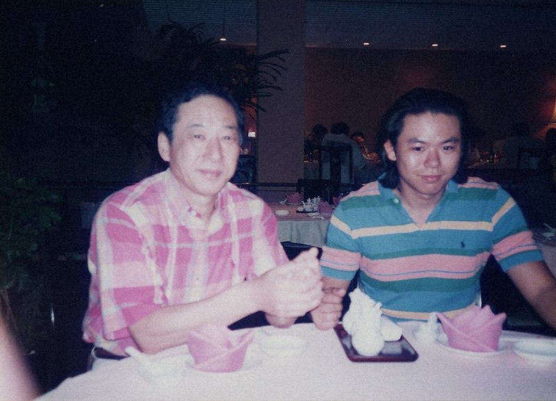 家族旅行中の小高集さん(右)と父=1998年、小高集さん提供
