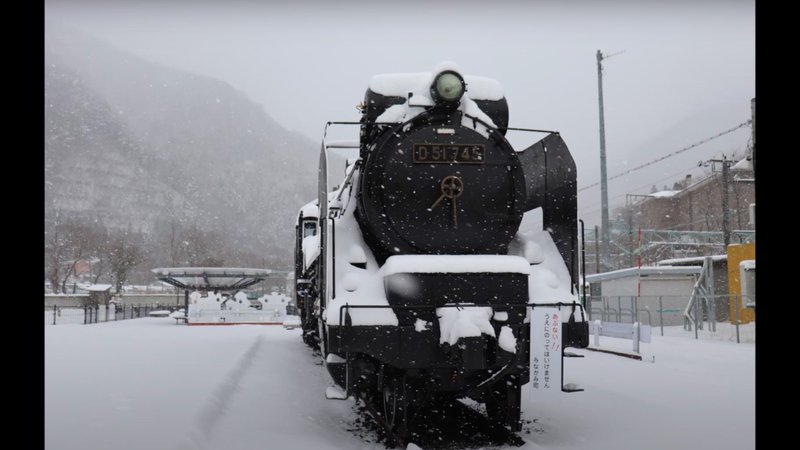 雪の中に佇む蒸気機関車の画像