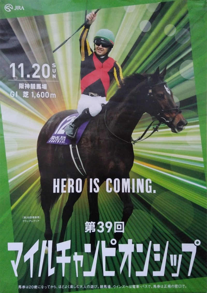 第39回マイルチャンピオンシップ2022ポスター画像。中央に昨年の優勝馬グランアレグリア。鞍上のクリストフ・ルメール騎手は右手を高々と挙げている。馬体の後ろからは後光のように放射状の光線が放たれている。ポスター全体のからーは緑色。
