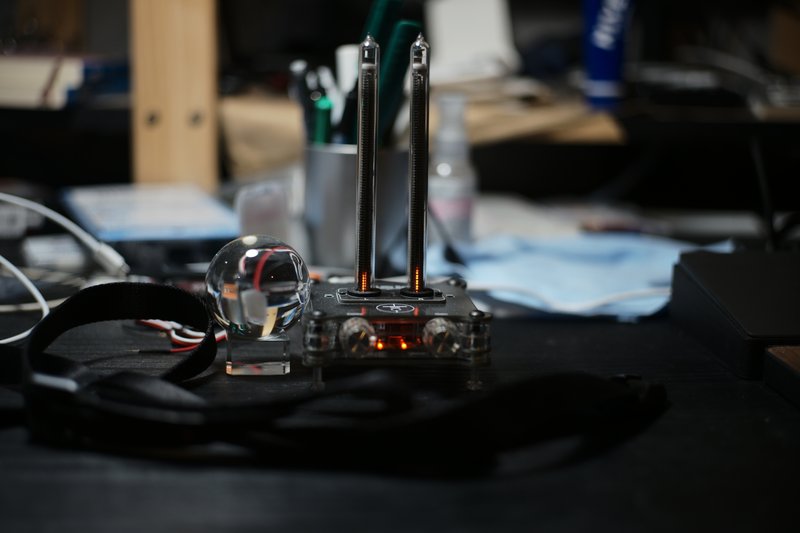 黒い机の上に水晶とガラス管型音量メーターが置かれている風景（カラー）