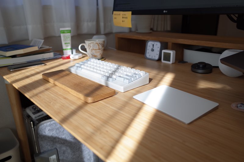 机の上にキーボードやマグカップ、ハンドクリームなどが置かれている写真