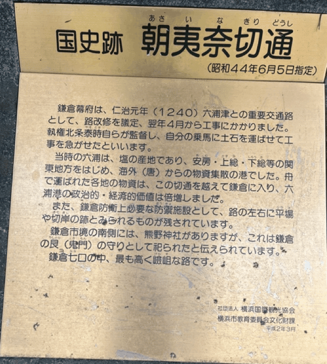 …当時の六浦は、塩の産地であり、安房・上総・下総等の関東地方をはじめ、海外（唐）からの物資集散の港でした。船で運ばれた各地の物資は、この切り通しを越えて鎌倉に入り、六浦港の政治的・経済的価値は倍増しました。　また、鎌倉防衛上必要な防禦施設として、路の左右に平場や切岸の跡と見られるものが残されています。鎌倉市境の南側には、熊野神社がありますが、これは鎌倉の<ruby>艮<rt>うしとら</rt></ruby>（鬼門）の守りとして祀られたと伝えられています。鎌倉七口の中、最も高く険阻な路です。