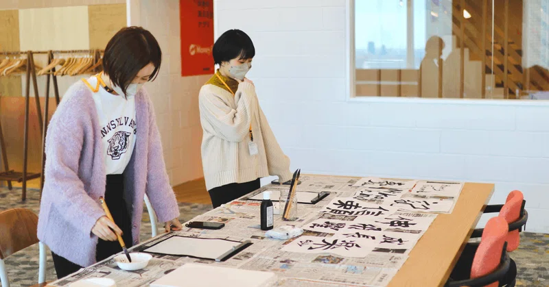メンバー2人が書き初めをしている画像