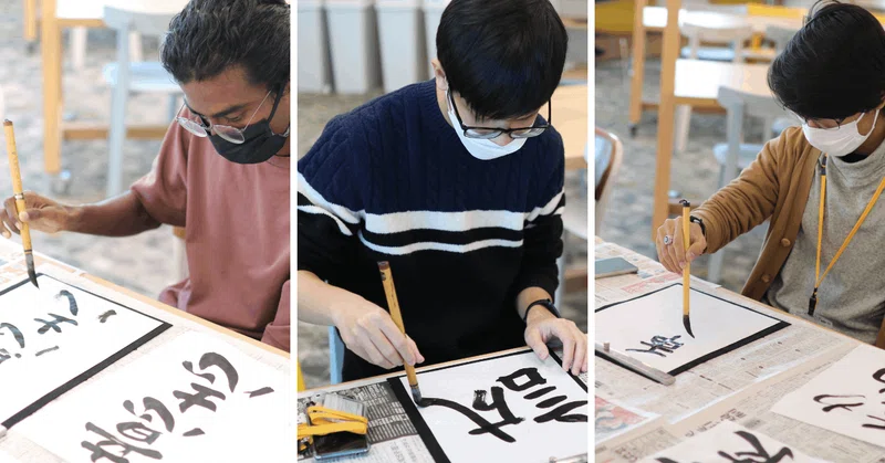 グローバルメンバー3人が書き初めをしている画像