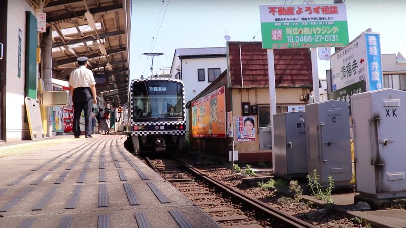 腰越駅を出発する江ノ電の写真