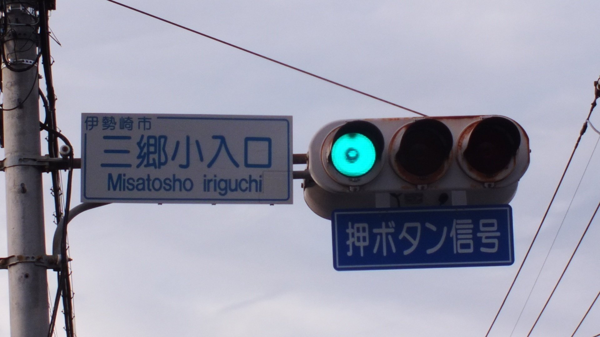 三郷小入口交差点に存在していた赤文字の押しボタン式信号機標示板が