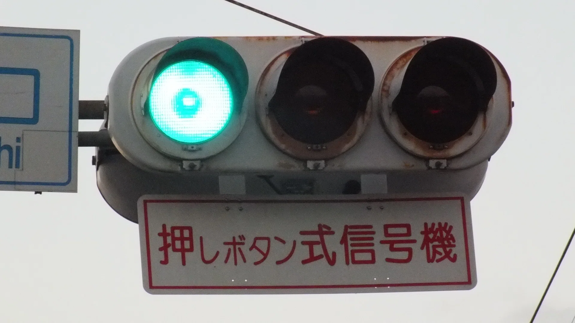 三郷小入口交差点に存在していた赤文字の押しボタン式信号機標示板が