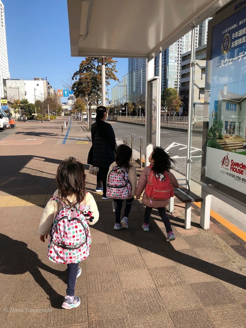 写真は、子ども三人とお母さんがバス停まで走って来た瞬間のものです。間に合いました。子どもたちは、お揃いの靴で、お揃いのパンダのキーホルダーをつけています。