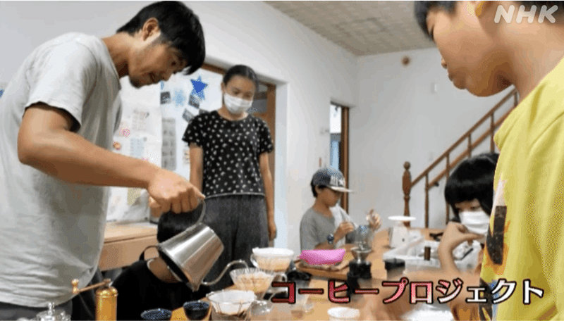 男性が珈琲豆にお湯を落としているところを興味深く見つめる子供４人。