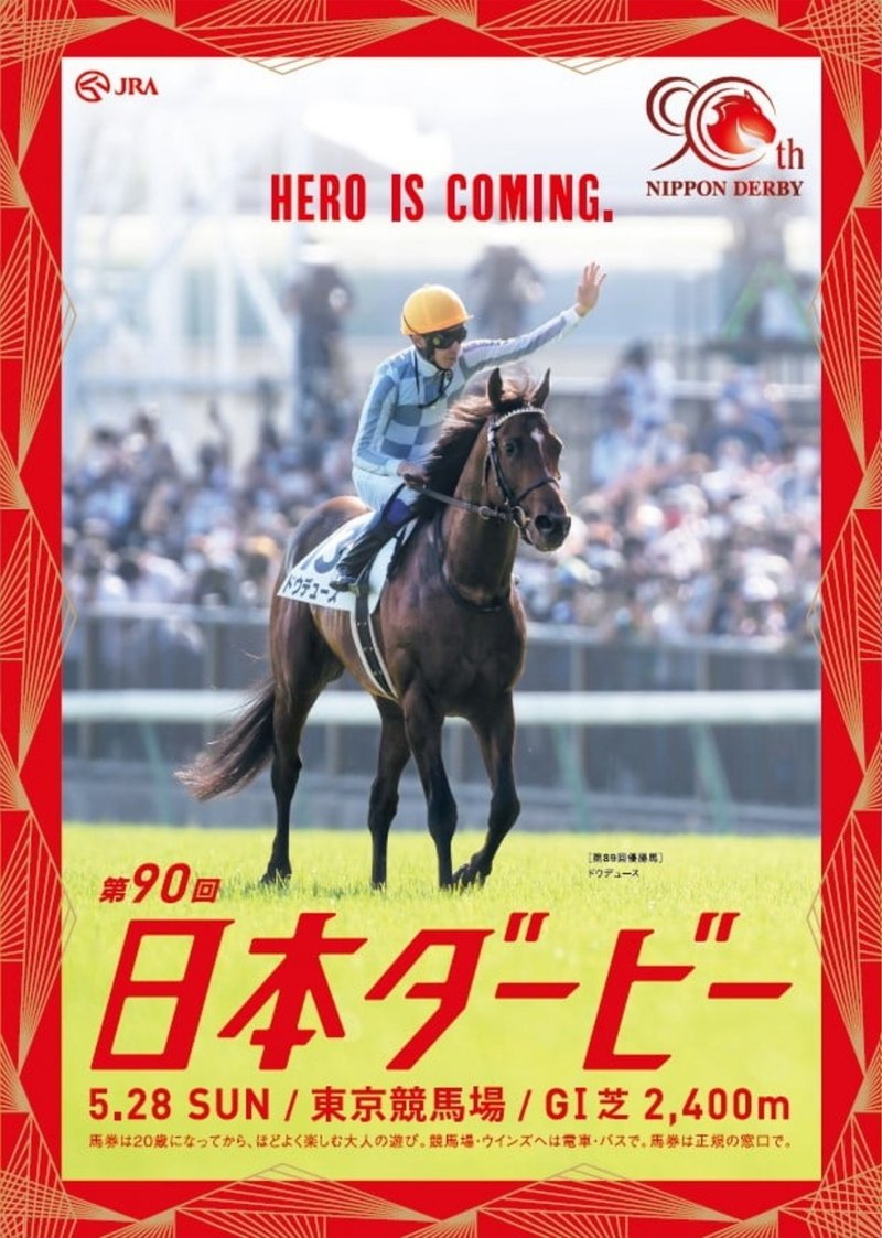 2023年5月28日に東京競馬場で行われる第90回日本ダービーのポスター。写真は昨年の優勝馬ドウデュース。ウイニングラン後のシーンで、鞍上の武豊が観客席にむかって左手をあげている。背景は実写（観客席）。縁取りは赤地に金色の線でできた幾何学模様。サイズや形の異なる三角形がいくつも重ねられている。