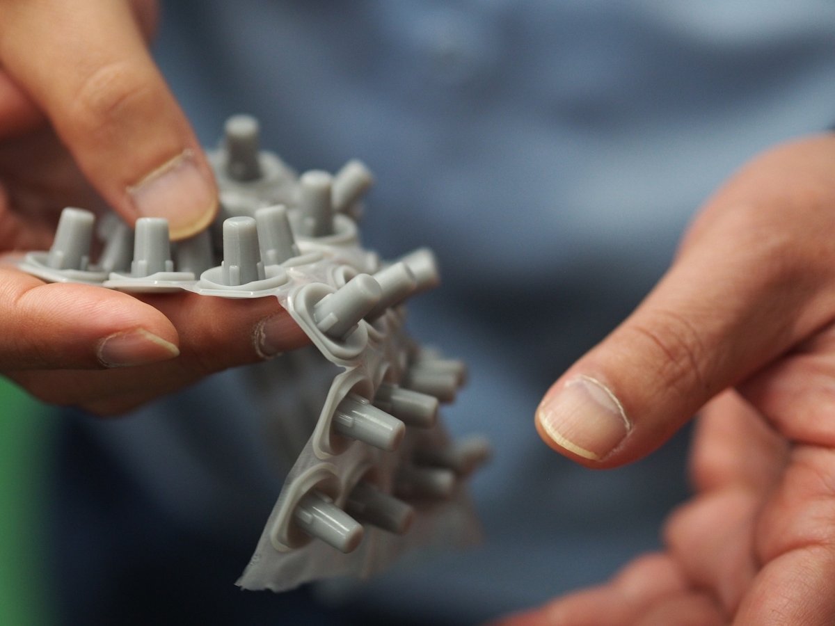 錦城護謨株式会社で製造しているゴム部品の一部を手に持った様子