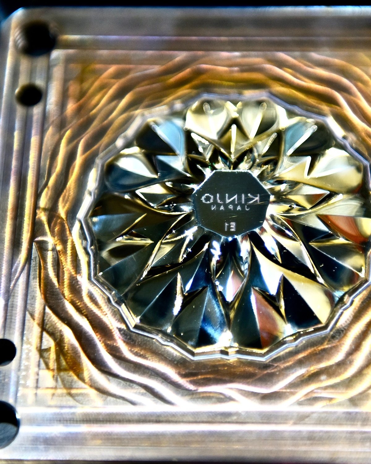 グラスの底面にあたる光り輝く金型