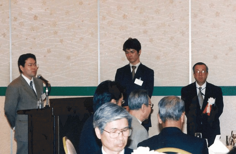 原田左官工業所に入社後、設立30周年の式典であいさつする原田宗亮さん（左奥）＝2000年、同社提供