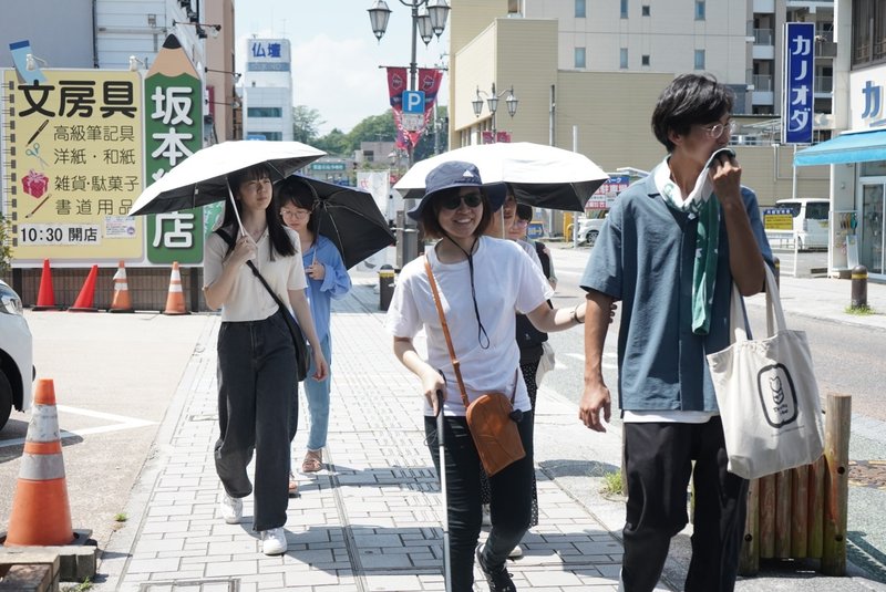 まち歩き中の様子　日差し除けのため日傘をさしていたり、帽子をかぶっていたり　猛暑日だった