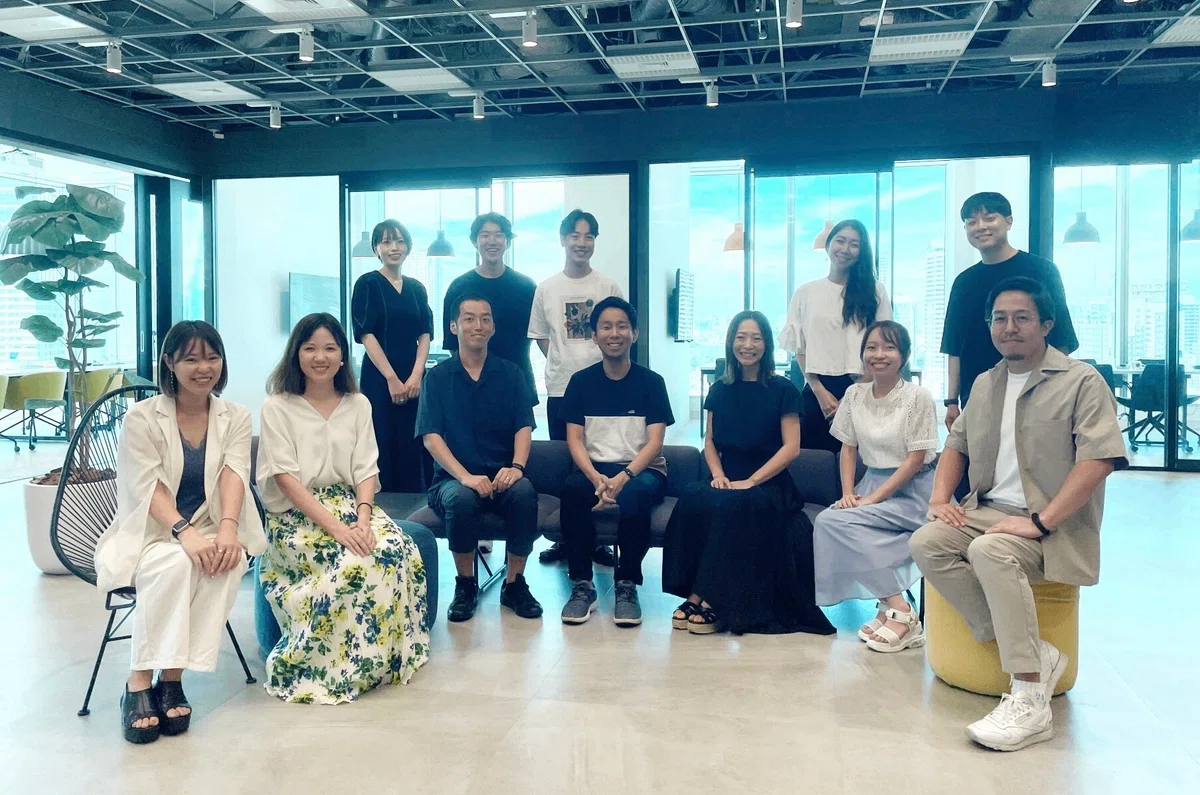 正面を向いて微笑む男女12人の写真。