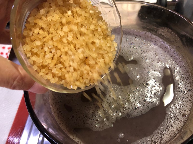 砂糖の分量の半量を小豆が入った鍋に加えて混ぜる