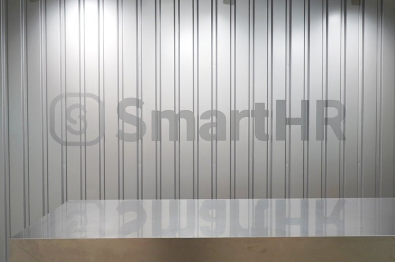 SmartHRと書かれた銀色の壁の写真。